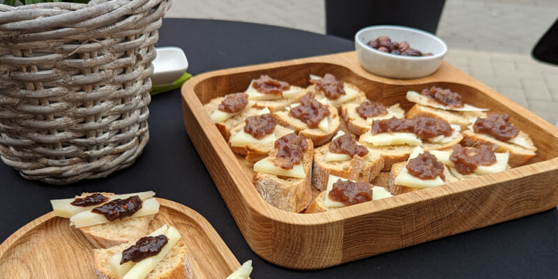 Brothäppchen mit Käse auf zwei Tabletts auf einem Stehtisch