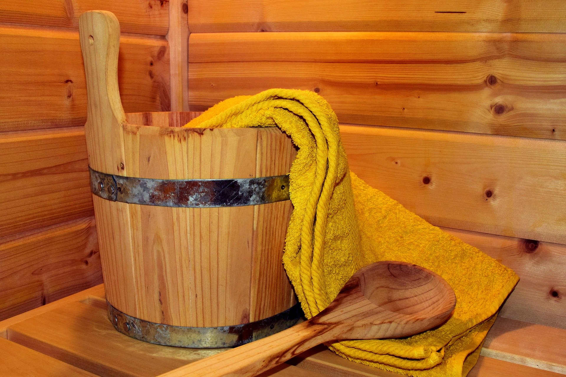 Eimer auf einer Holzbank mit Handtuch und Löffel