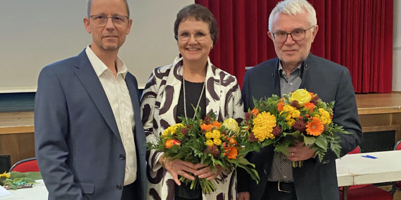 Zwei Männer und eine Frau mit Blumensträußen