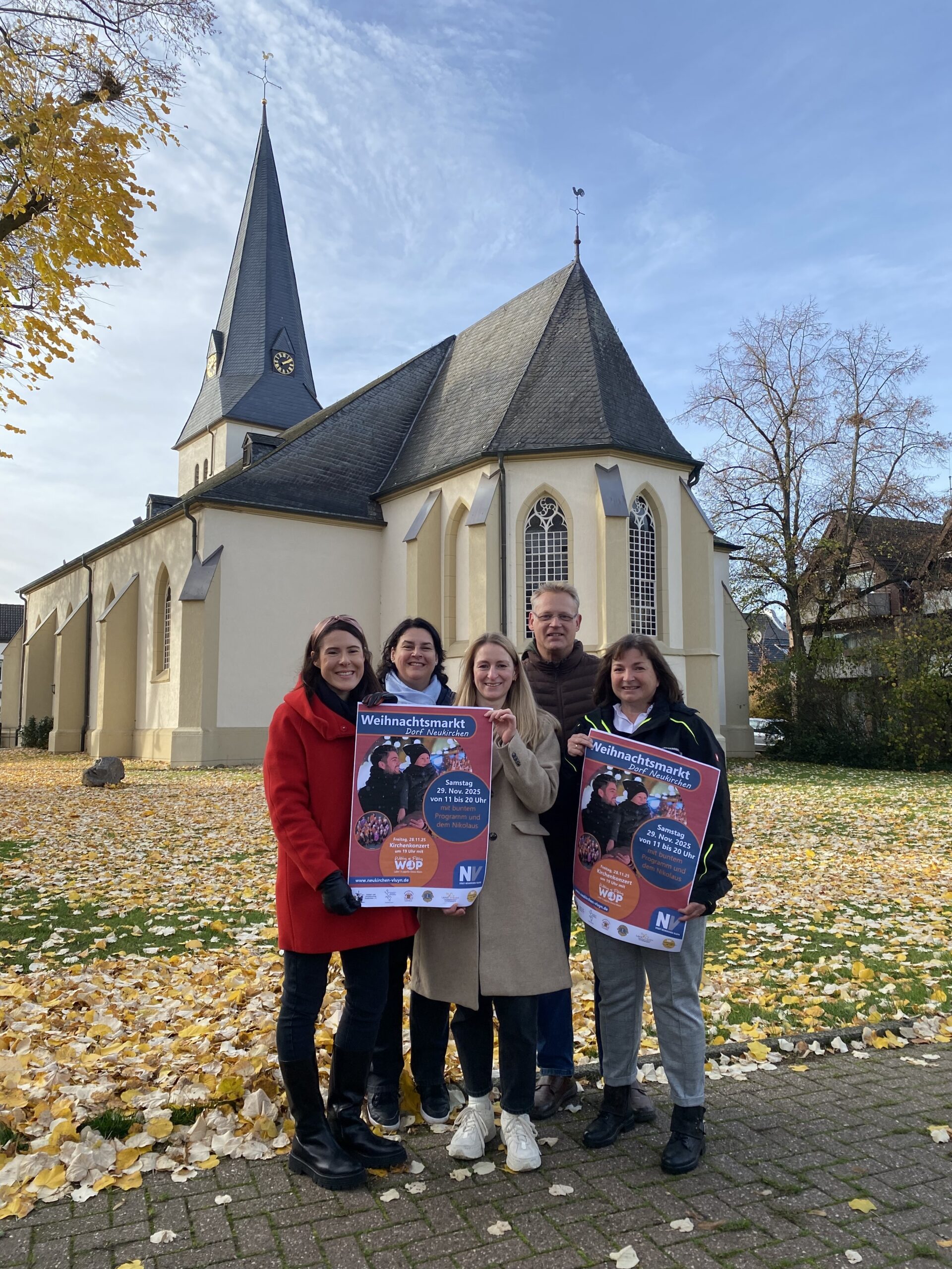 Fünf Menschen mit Plakaten, im Hintergrund eine Kirche