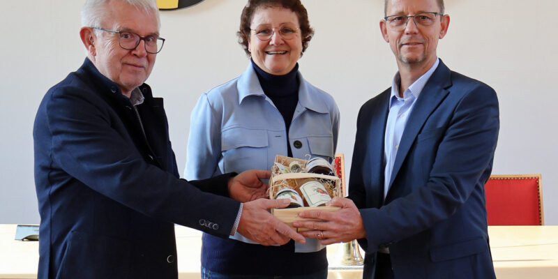 Drei Personen halten einen Geschenkekorb