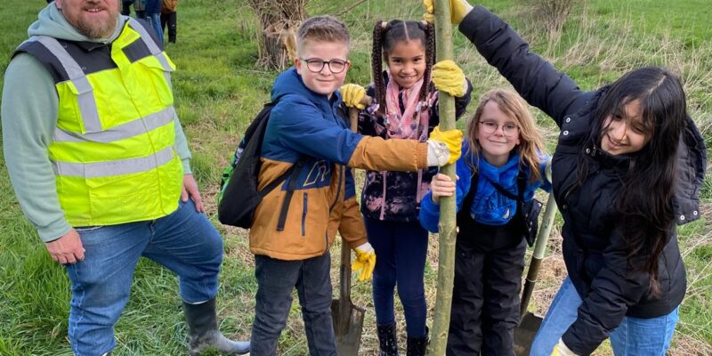 Kinder setzen Baum ein