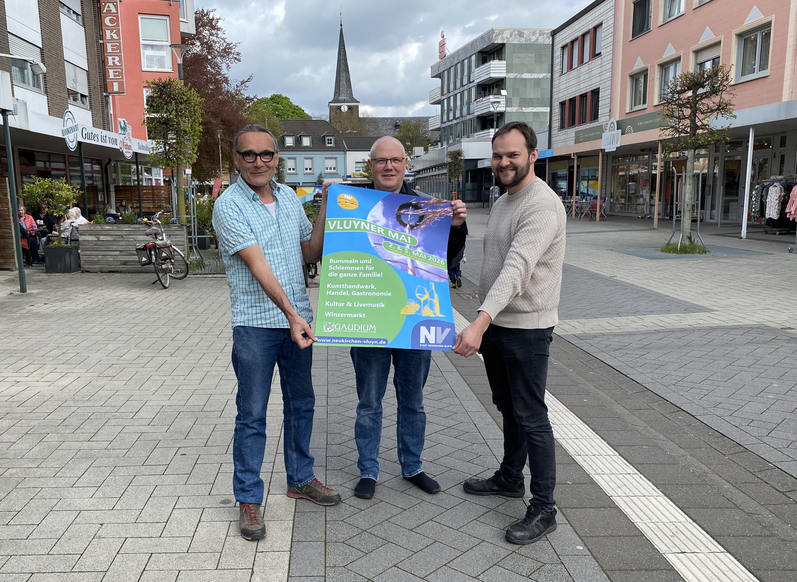 Drei Männer halten ein Plakat