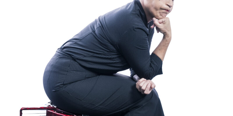 Frau sitzt auf Akkordeon